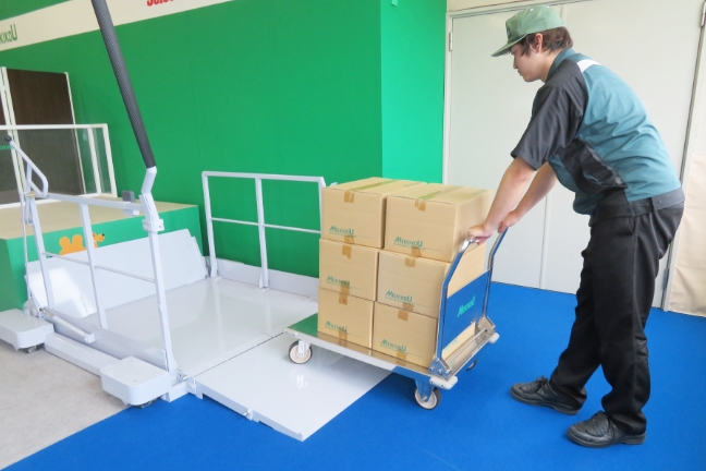 トラックから荷をおろす・積み込む、移動式段差解消用シザーリフト、段差らく~だ、スロープに台車をのせる
